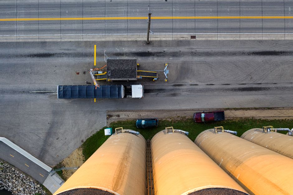Aerial shot of industrial silos with trucks on a road in Red Wing, MN.